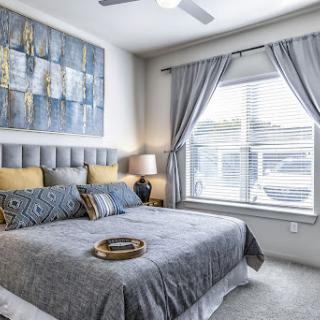 A modern and cozy bedroom featuring a stylish gray color scheme, comfortable furnishings, and artistic accents.