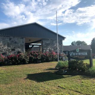 A welcoming facility with a landscaped entrance and a clear sky.