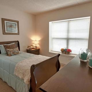 A cozy bedroom with a single bed and soft lighting.