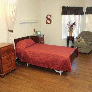 A cozy bedroom with a single bed, wooden flooring, and simple decor.