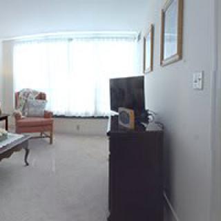 A cozy living room with a television, armchair, and coffee table.