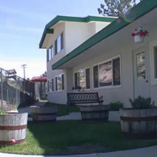 Exterior view of a building with green trim and a bench outside.