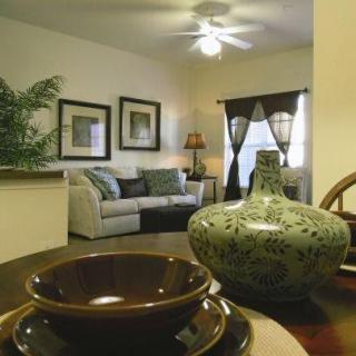 A cozy living room with elegant decor, featuring a stylish couch, artwork on the walls, and a decorative vase on the table.