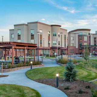 A modern building surrounded by landscaped gardens and curved pathways.