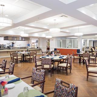 A modern dining area with neatly arranged tables and chairs, featuring stylish lighting.
