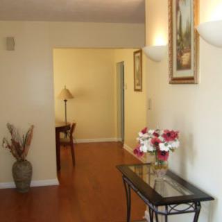 A well-decorated hallway featuring a table with flowers, a vase, and wall art.