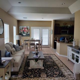 A cozy living space with an open layout, featuring a sofa, dining area, and kitchen.
