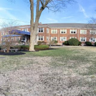 A sunny day at the school, showcasing the building and surrounding greenery.
