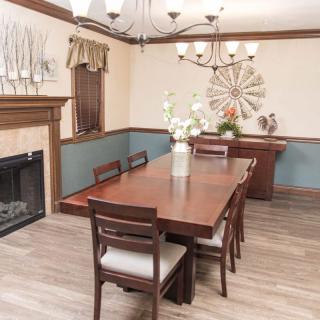 A cozy dining room with a wooden table, elegant chandelier, and tasteful decor.