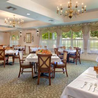 An elegant dining room with beautifully set tables and chandeliers.