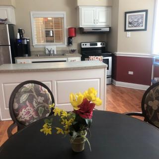 A cozy kitchen and dining area with a table set with flowers in the foreground.