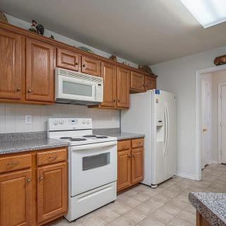 A modern kitchen with wooden cabinets and standard appliances.