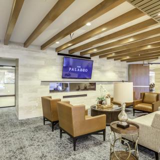 A modern lounge area featuring comfortable seating and a wall-mounted television.
