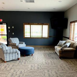 A cozy living room setting featuring comfortable furniture and ample natural light.