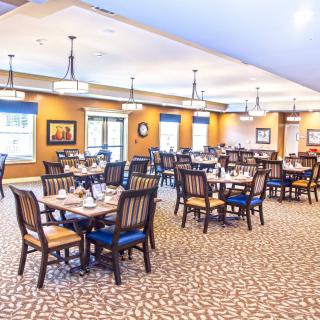 A spacious and well-lit dining area with neatly arranged tables and chairs.