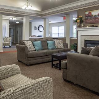 A cozy living room with sofas, armchairs, and a fireplace.