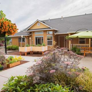 A charming residential home with a well-maintained garden and patio area.