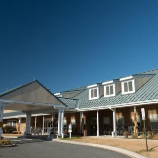 A spacious building with a prominent entrance under a clear blue sky.