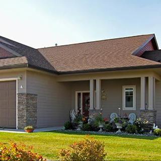 A suburban residential house with a well-maintained lawn and attached garage.