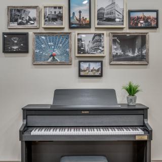 A stylish music room featuring a piano and a wall of framed photographs.