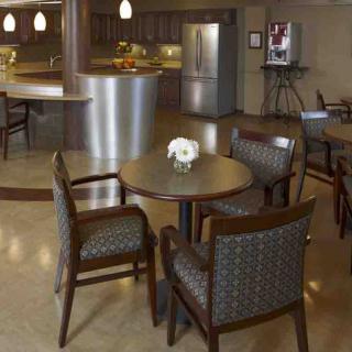 A modern kitchen and dining area with a round table, chairs, and a stainless steel refrigerator.