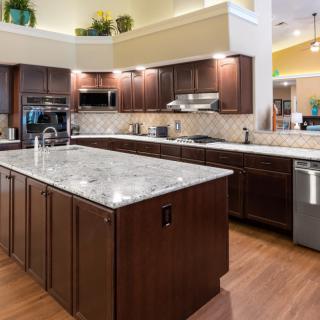 A modern kitchen with dark wood cabinets and a large island countertop.