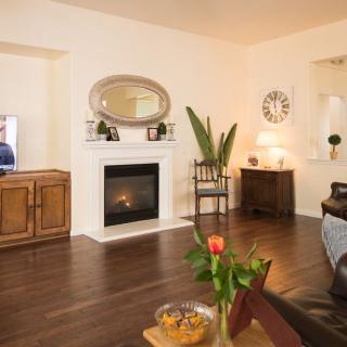 A cozy living room with a fireplace, wooden floors, and stylish decor.