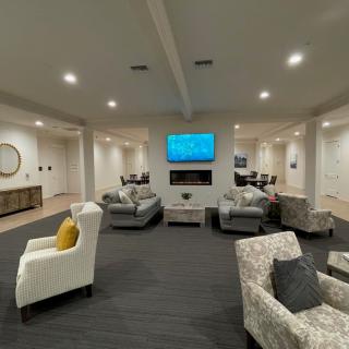 A modern living room with comfortable seating and a mounted television.