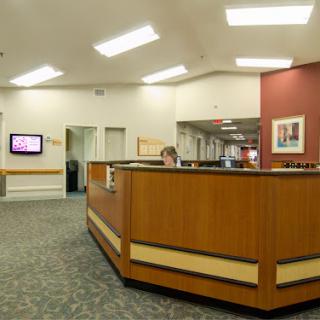 A modern reception area featuring wooden furniture and bright lighting.