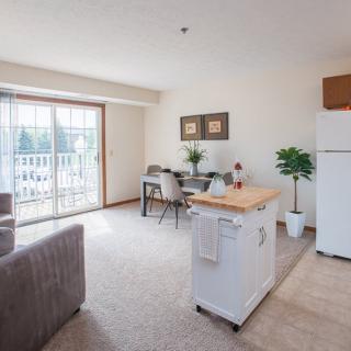 A bright and airy open-plan living and dining area with a kitchen island and large sliding doors.