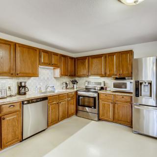 A modern kitchen with wooden cabinets and stainless steel appliances.