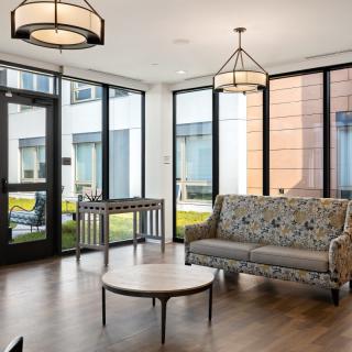 A modern living room with large windows, cozy sofa, and stylish lighting.
