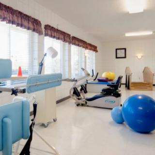 A rehabilitation room equipped with exercise and physical therapy equipment.
