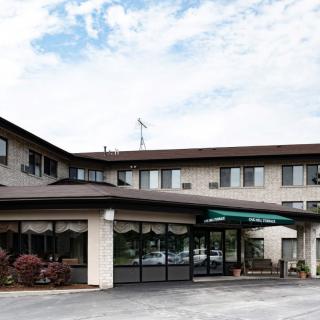 Exterior view of a hotel entrance under a partly cloudy sky.