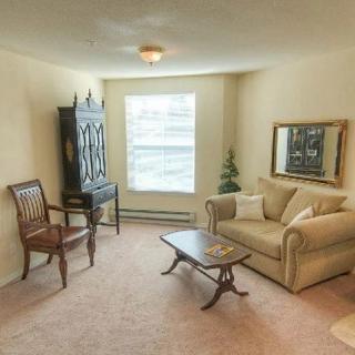 A cozy living room with a sofa, chairs, and decorative furniture.