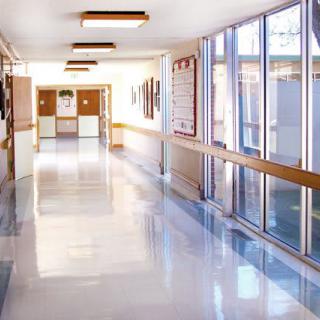 A bright and clean hospital corridor with large windows.