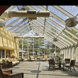 A spacious atrium with a glass ceiling, featuring comfortable seating arrangements and ample natural light.