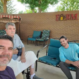 Three friends enjoying a relaxed moment together in an outdoor seating area.