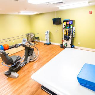 A well-equipped rehabilitation gym featuring various exercise and therapy equipment.