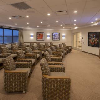 A modern waiting room with patterned chairs and artwork on the walls.