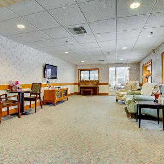 A spacious living room with comfortable seating, a TV, and large windows.