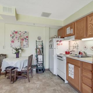 A cozy kitchen and dining area with wooden cabinets and a small table.
