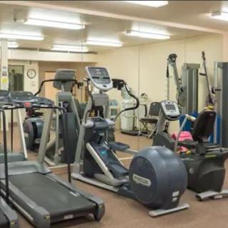 A well-equipped gym with various fitness machines and weights.