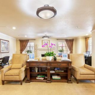 A well-decorated living room with sofas, a wooden table, and vibrant flowers as the centerpiece.