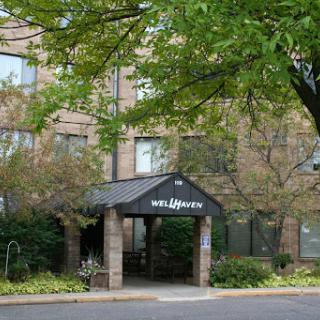 A welcoming entrance to a building, surrounded by lush greenery.