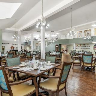 A spacious and elegantly designed dining area with neatly arranged tables and chairs.