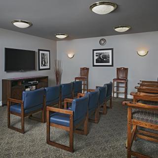 A small meeting room with rows of chairs facing a television.