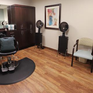 A cozy interior of a hair salon featuring styling chairs and hairdryers.