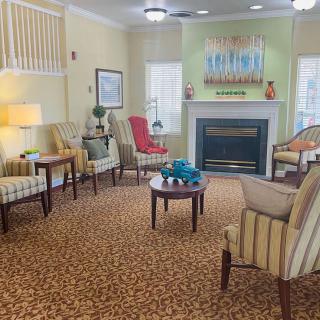 A cozy living room with comfortable seating around a fireplace and decorative artwork on the walls.