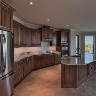 A spacious, modern kitchen with wooden cabinets, stainless steel appliances, and an island.